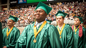 Smiling students walks into graduation